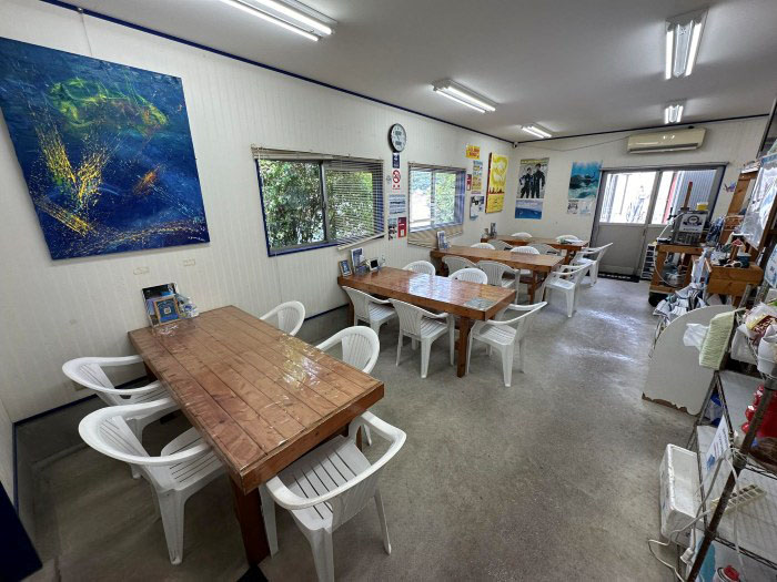 海が目の前にある店舗内。グループごとにテーブル利用が可能。アウトサイドにも大きなテーブルを設置