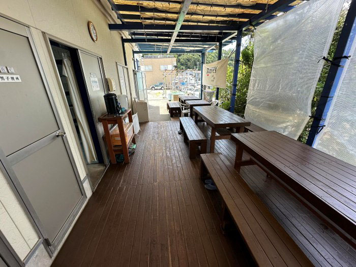 外のデッキに設置されたテーブルはグループでの利用に便利。左手には更衣室、トイレ、シャワー施設が並んでいます