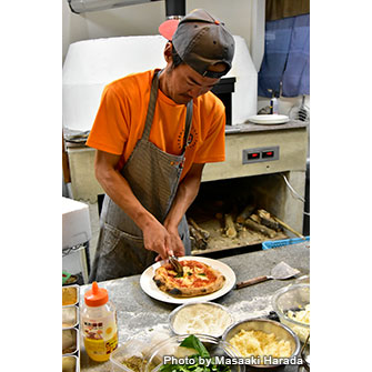 オーナーの川満隼人さん。石窯で作ったピザも絶品だ