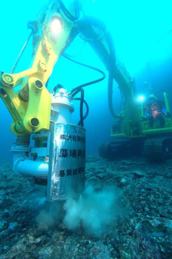 プロ潜水士は水中バックホウ（施工機械）も使いこなす（写真:渋谷潜水工業）