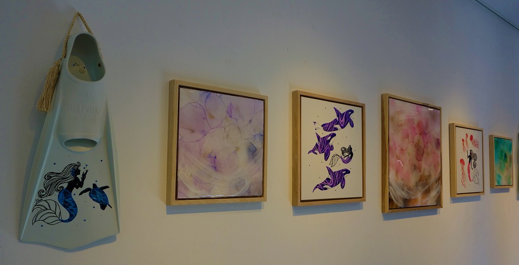 YURIEさんがフィンに描いたウミガメや壁かけアート、MIHOさんのアルコールインクから描かれる風のような表現など個々の作品も飾られていた