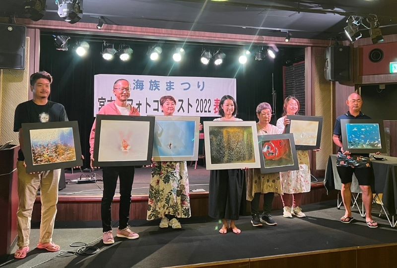 宮古島フォトコンテスト2022の受賞者の皆さんと審査員・上出俊作さん（左から２番目）