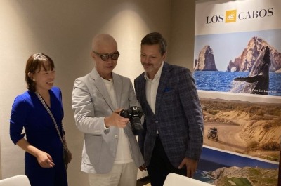 撮影カットをチェックするロドリゴ・エスポンダ局長。左は日本地区マネージャー志田朝美さん